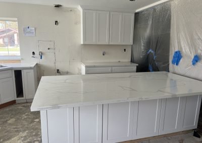 Kitchen remodel in progress with quartz island and white shaker cabinets — Bakersfield CA