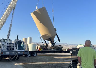 Crane lifting industrial tanks at commercial site — industrial contractor Kern County
