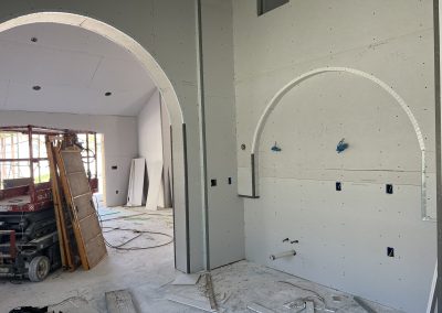 Arched drywall openings in luxury home with scissor lift — custom residential construction Bakersfield