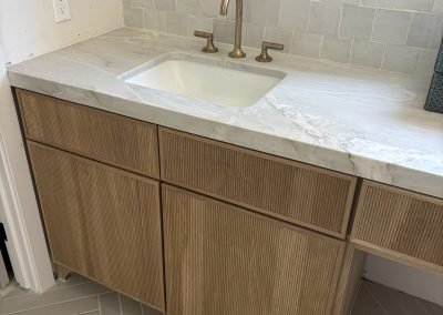 Ribbed wood vanity with brass fixtures — custom bathroom remodel Kern County CA