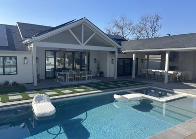 Backyard pool with covered patio and outdoor kitchen pergola — luxury home remodel Kern County