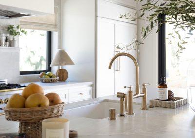 Unlacquered brass bridge faucet and marble countertops — custom kitchen remodel Kern County CA