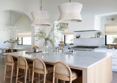 Open plan kitchen with custom oak island, raffia pendants, and arched doorways — luxury home remodel Bakersfield CA