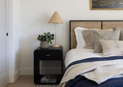 Custom bedroom with cane headboard and wide plank white oak floors — luxury home remodel Kern County CA